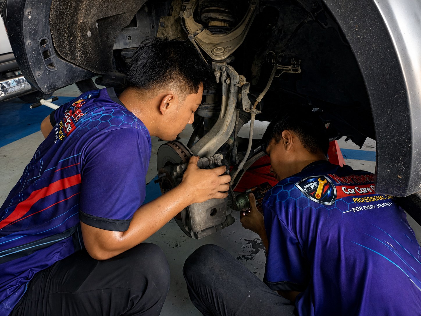 Northeast Car Care Centre mechanics inspecting a vehicle suspension and brake assembly