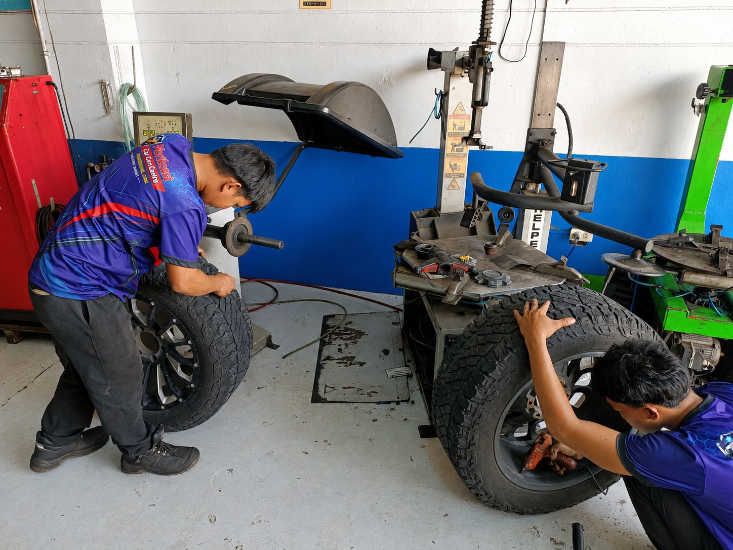 Northeast Car Care Centre mechanics servicing off-road vehicle tires